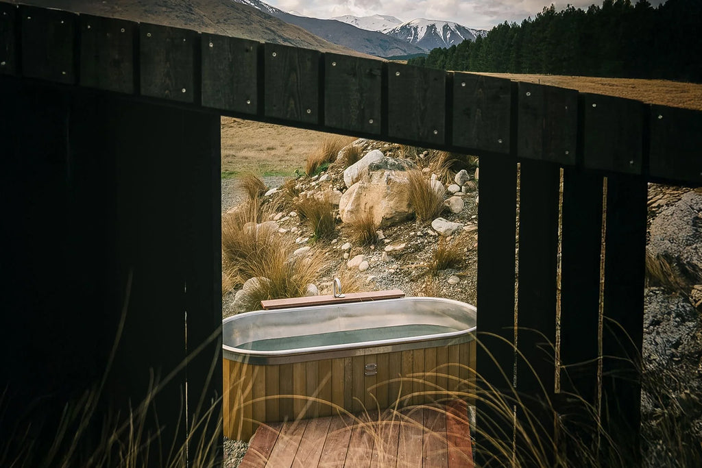 Stainless steel electric outdoor bath with cedar cladding in alpine New Zealand landscape