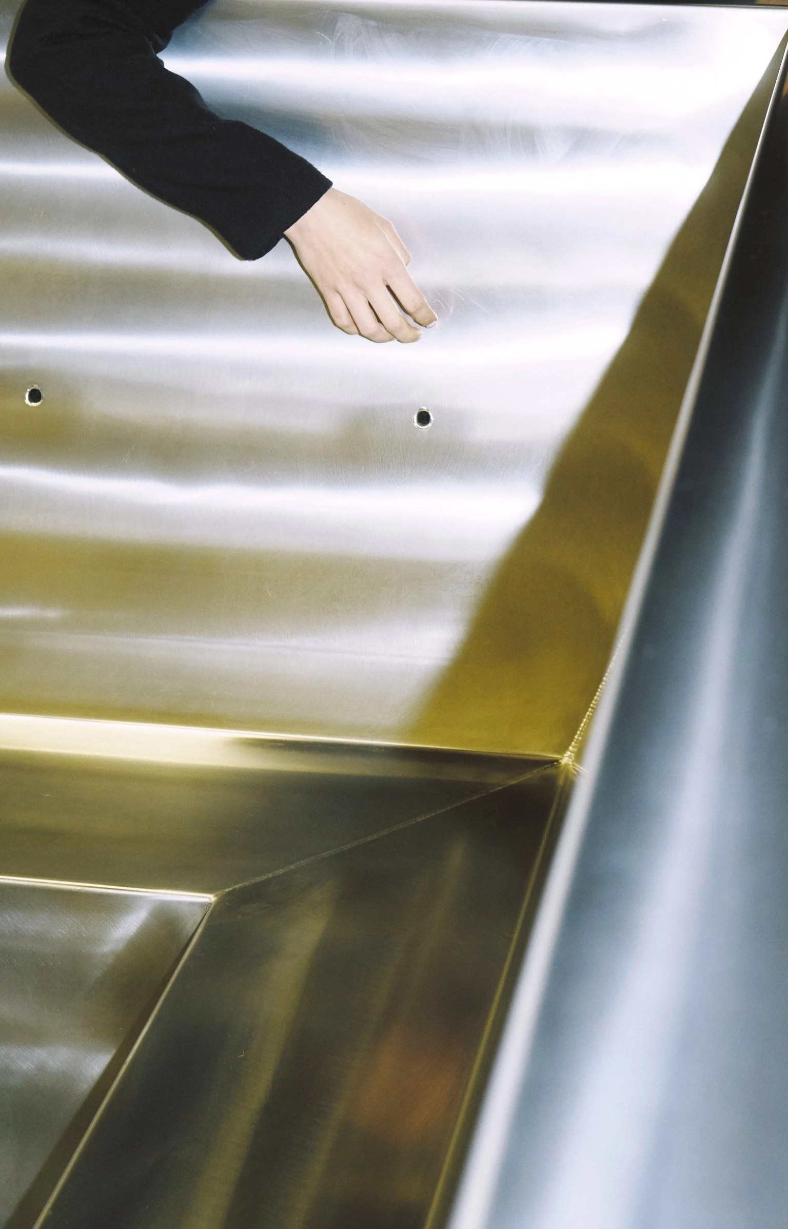 A hand touching the stainless steel interior of a Stoked tub